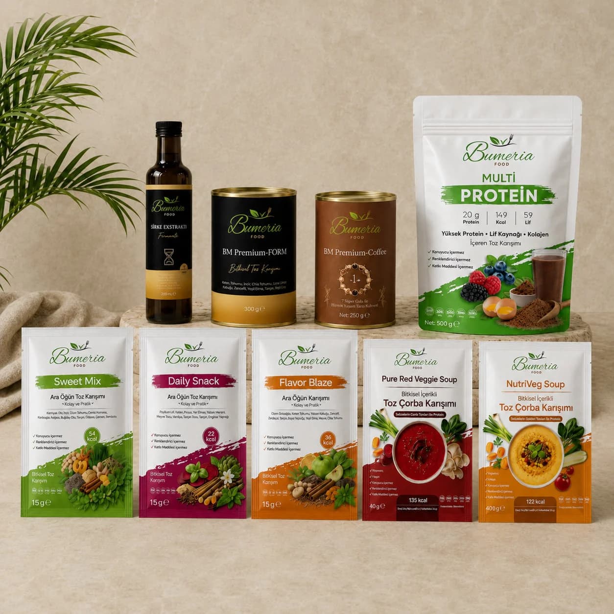 Bumeria Food blog kapağı: açık zeminde arka sırada sirke ekstraktı şişeleri, BM-Premium kutuları ve Multi Protein paketi, önde renkli toz karışım ve çorba paketleri.