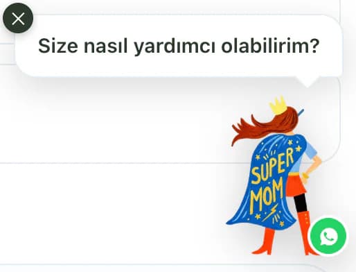 The Süper Anne mascot in the bottom right corner of the Tam store: a mother character in a Super Mom cape with a WhatsApp badge and a speech bubble asking how she can help.