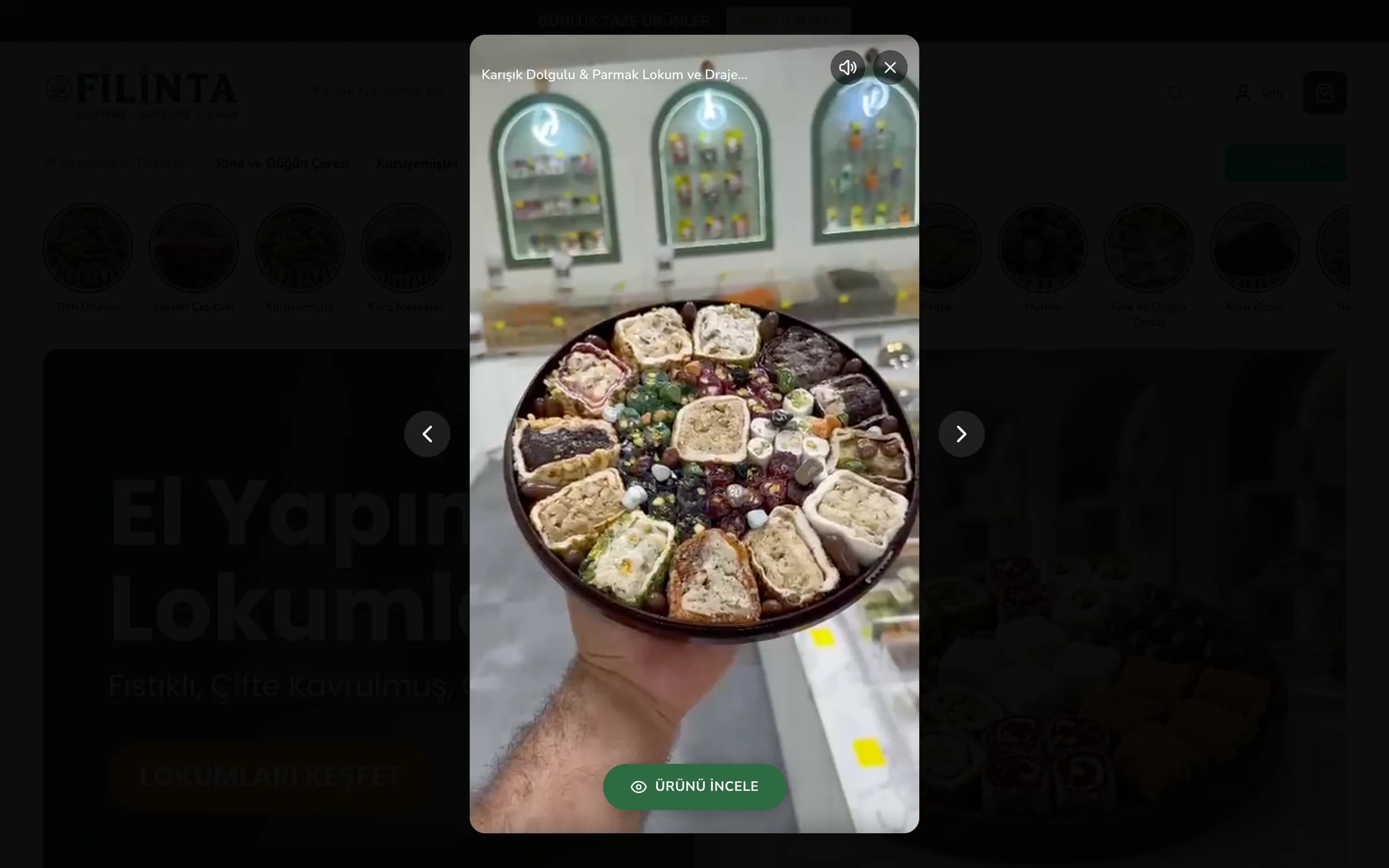 Filinta Kuruyemiş ana sayfasında masaüstünde açılan hikâye: kararan sayfanın ortasında dikey video penceresi; dükkânın yeşil kemerli rafları önünde elde tutulan, sarma ve parmak lokumlarla dolu yuvarlak tepsi, üstte Karışık Dolgulu & Parmak Lokum ve Draje... başlığı, ses ve kapatma düğmeleri, altta yeşil Ürünü İncele düğmesi, iki yanda önceki ve sonraki okları.