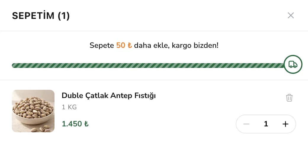 Filinta Kuruyemiş sepet çekmecesinin üstü, masaüstünde: Sepetim (1) başlığı, Sepete 50 ₺ daha ekle, kargo bizden! yazısı ve ucunda kamyon simgesi olan neredeyse dolu yeşil çizgili çubuk; altında sepetteki 1 kg Duble Çatlak Antep Fıstığı, 1.450 ₺ fiyatı ve adet seçici.