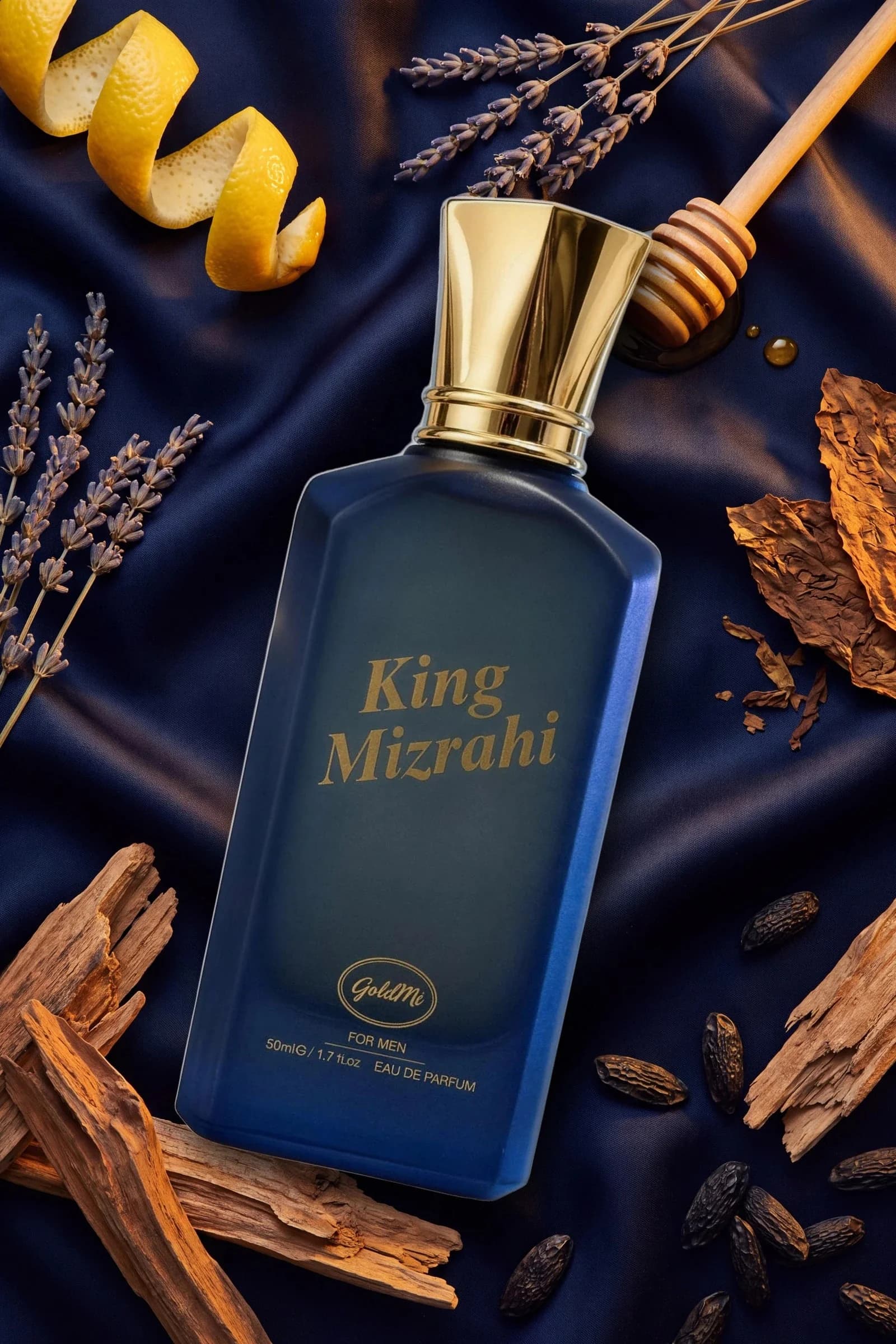 King Mizrahi Dark Blue fotoğrafı: lacivert saten üzerinde yatan şişenin çevresinde notaları anlatan limon kabuğu, lavanta, bal kaşığı, tütün yaprağı, tonka ve sedir parçaları.