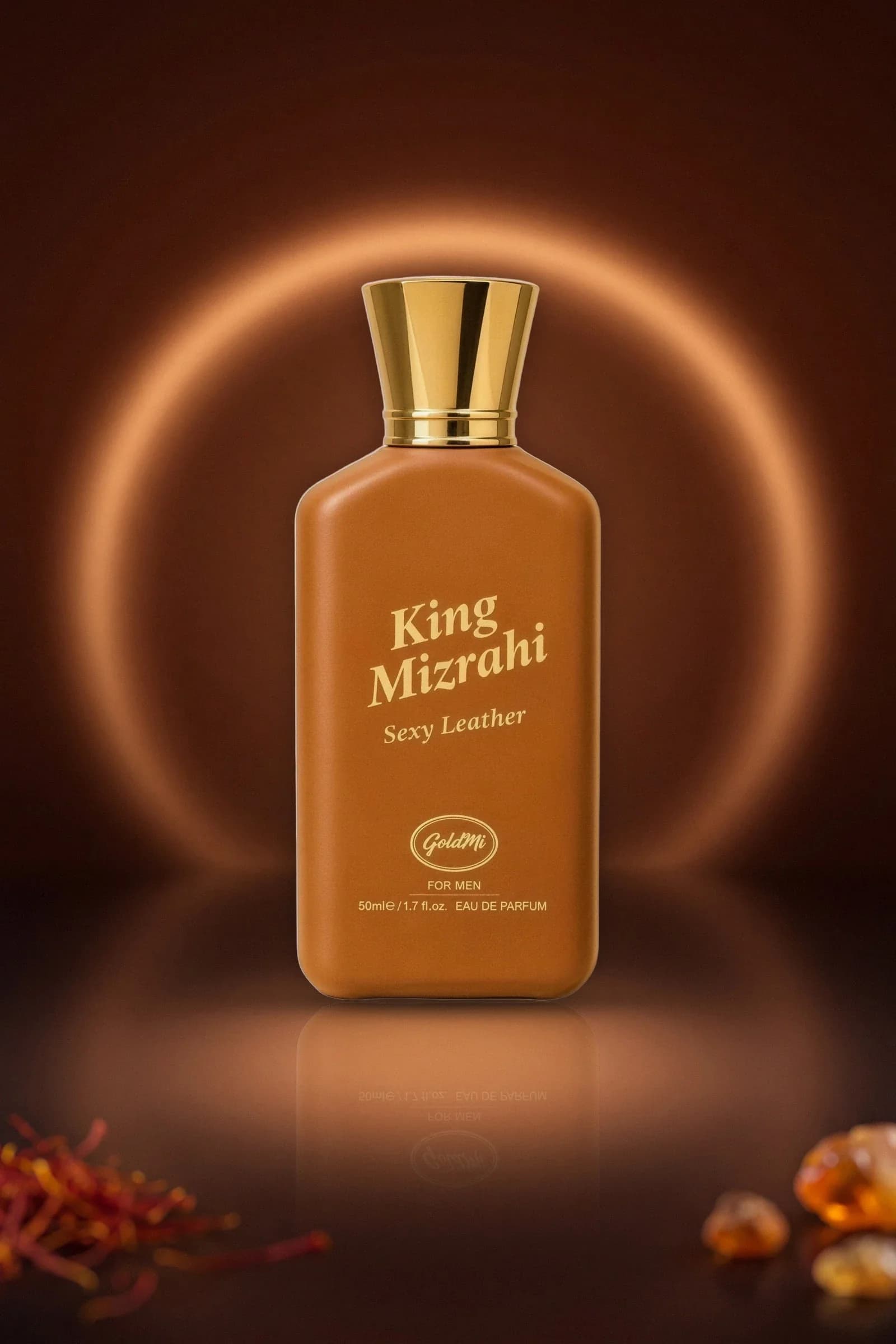 King Mizrahi Sexy Leather ürün fotoğrafı: kahverengi zeminde arkasında ışık halkası olan taba renkli şişe, önünde safran ve amber parçaları.