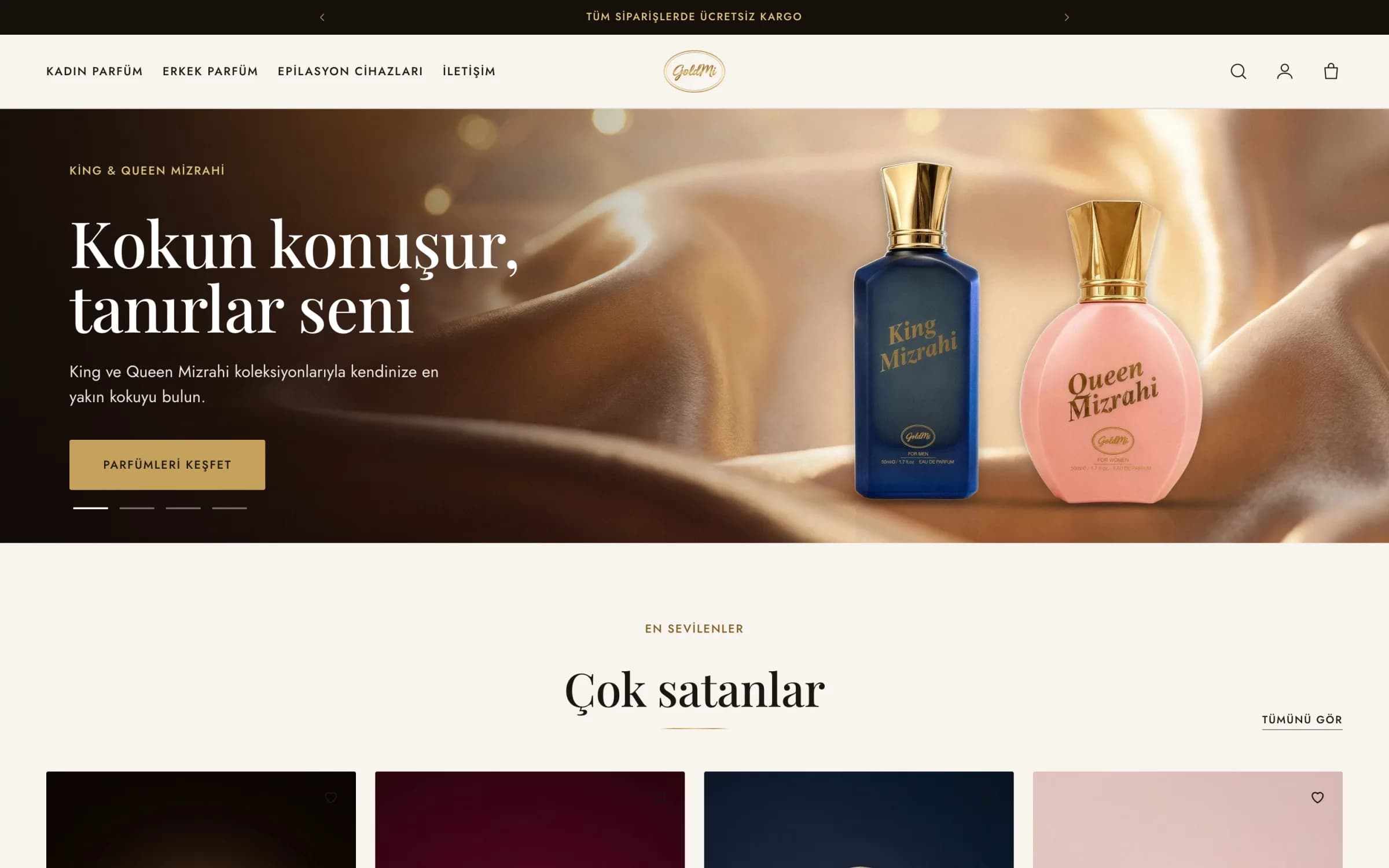 Goldmi'nin masaüstü ana sayfası: koyu duyuru çubuğunda Tüm siparişlerde ücretsiz kargo, solda Kadın Parfüm, Erkek Parfüm, Epilasyon Cihazları ve İletişim menüsü, ortada oval altın GoldMi logosu; açılış slaytında şampanya rengi saten önünde lacivert King Mizrahi ve pembe Queen Mizrahi şişeleri, Kokun konuşur, tanırlar seni başlığı ve altın Parfümleri keşfet düğmesi; altında Çok satanlar başlığı.