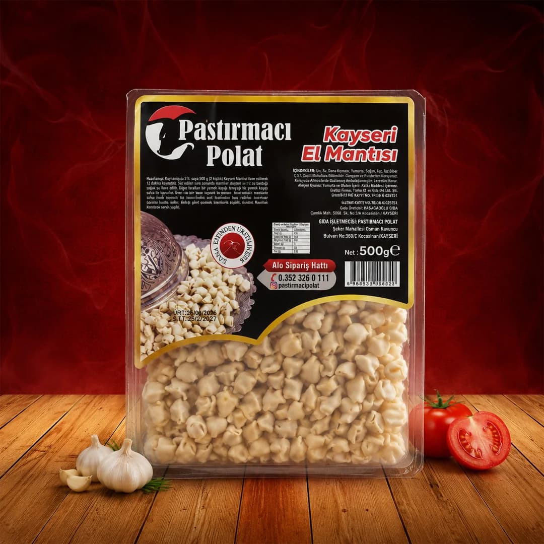 Pastırmacı Polat ürün fotoğrafı: kırmızı zeminde ahşap yüzeyde duran, Pastırmacı Polat Kayseri El Mantısı etiketli 500 gramlık şeffaf mantı paketi, yanında sarımsak ve domates.