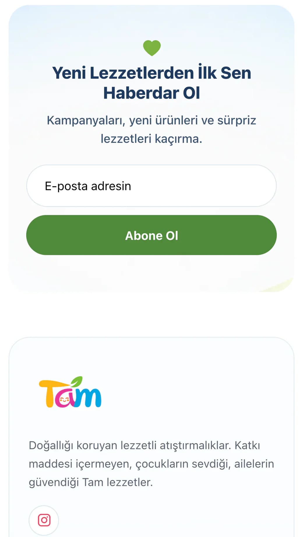 Tam ana sayfasının sonu telefonda: yeşil kalp simgeli Yeni Lezzetlerden İlk Sen Haberdar Ol abonelik kutusu, E-posta adresin alanı ve yeşil Abone Ol düğmesi; altında özel alt bilginin başı: renkli Tam logosu, doğallığı koruyan lezzetli atıştırmalıkları anlatan kısa marka açıklaması ve Instagram simgesi.